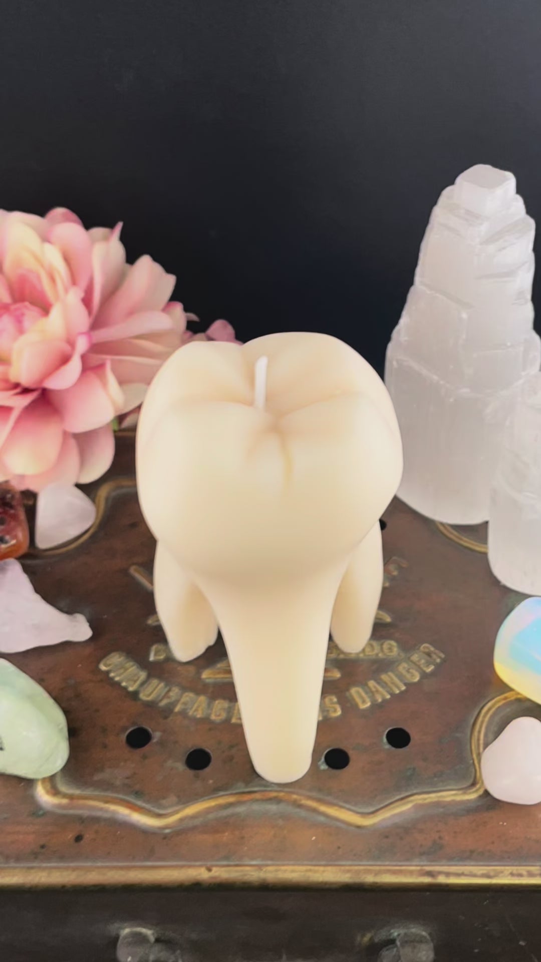 A time lapse video of a tooth candle melting and revealing a brass tag with hand-stamped text that reads "TRY ORGASM",